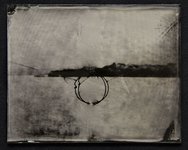 Landscape becomes abstract field of bright silver /w moire pattern. Dark fine gestures form a circle @ctr intersected by broad stroke of horizon