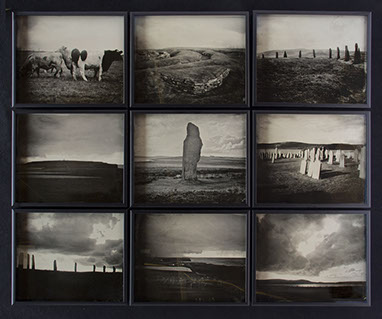 A 3x3 grid of glass photographs on black velvet in matte black frames. Depict Orkney landscapes of grassy hills, monoliths, cows, graves & shore