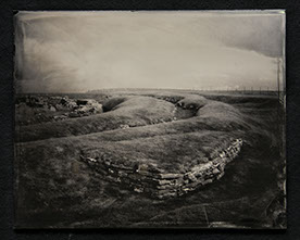 Panel A2 is a grassy landscape graced with waving mounds & stone buildings. Two walls of bricks meet to support the large mound in foreground.