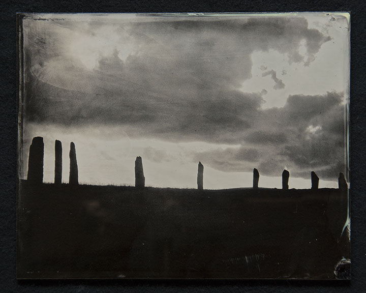 Panel C1 depicts a low landscape in silouette topped with monoliths surrounded by bright sky with dark rolling clouds above.